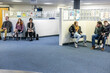 © Connect Images - People waiting in a seating area of a medical practice in the UK