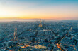 © Image Source - Aerial view of Paris with the Eiffel Tower illuminated at dusk.
