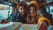 © familymedia - A couple in warm clothing smiling inside a van with a map