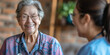 © nopommajun - A middle-aged doctor wearing scrubs is engaging with an elderly patient