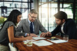 © Katleho Seisa/peopleimages.com - Businesspeople, deal and meeting with documents in boardroom, office and sign for corporate b2b sale. Collaboration, attorney with paperwork and contract, management and planning for negotiation