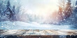 © Nice Seven - empty wooden table top on snow background. Snowy winter landscape with snow-covered trees and a wooden deck in the foreground, creating a serene and picturesque scene with soft morning light.