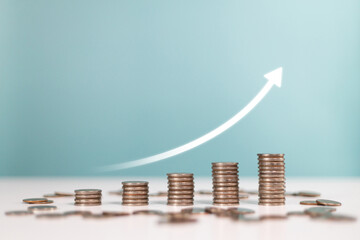 Invest,Investment,profit, saving money,finance and business strategy. Upward arrows with increasing piles of coins Indicating sales profit