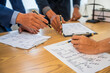 © M+Isolation+Photo - A team meeting of business people and a lawyer in formal suits is taking place at a desk, discussing a contract and various aspects of the law and litigation.