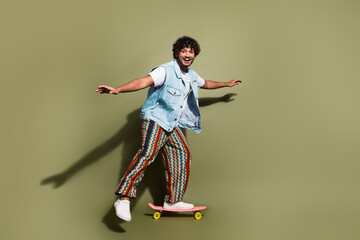 Sticker - Full length photo of nice young male ride skateboard have fun dressed stylish denim garment isolated on khaki color background