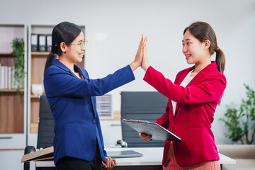 Wall Mural - Two successful Asian businesswomen collaborate, discussing comments and suggestions on various financial matters, including the stock market, loans, securities law, and investment strategies.