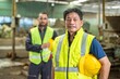 © BESTIMAGE - Portrait of a senior Asian industrial worker wearing safety vest and hard hat, standing in a factory.