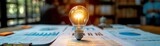 Insightful business meeting A light bulb brightly shining above detailed business documents, casting light on strategic insights in a professional setting