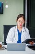 © NanSan - Asian female doctor specializes in psychiatry, providing online consultations and psychotherapy from her desk. She offers diagnosis, treatment, counseling, and medication for mental health disorders.