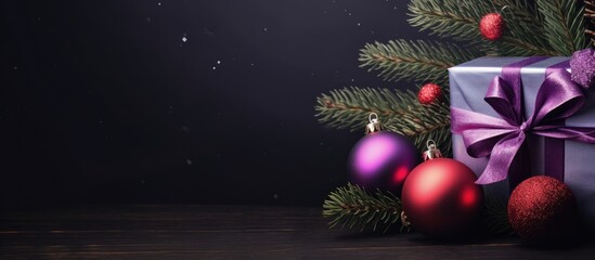 Wall Mural - Christmas tree branch with purple and red wavy ball gift box on a dark background Flat lay with copy space