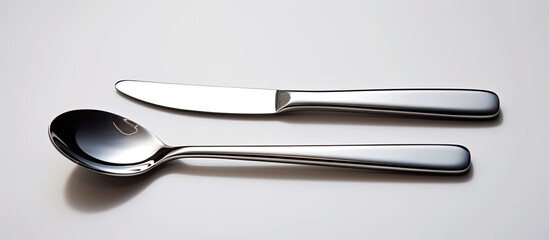 Poster - set of metal cultery equipment on the white table spoon fork and knife. copy space available