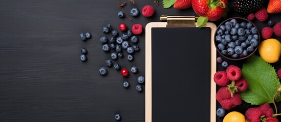 Aufkleber - Flat lay of hand writing on clipboard notepad paper mock up copy space viewed from above over dark background decorated with wild berry fruit arrangement
