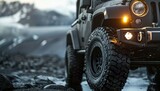 Close up of the rugged tires and black metallic bodywork on an offroad vehicle