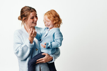 Wall Mural - Mother and daughter embracing in front of white background, love and family concept, happy together