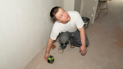 Builder worker makes repairs in the apartment. House renovation. Professional measuring device