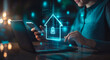 © Danimotions - Businessman using mobile phone and laptop with home security system icon hologram floating in the air