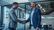 © wolfhound911 - a Caucasian entrepreneur shaking hands with a new partner in a modern conference room