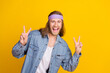 © deagreez - Photo portrait of attractive young hippie man show double v-sign wear trendy denim outfit isolated on yellow color background