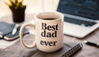 © annebel146 - White mug with the text 'Best dad ever' on workplace. Office desk. Father's Day concept, background for congratulating cards with a cup with the inscription Best Father ever, business notebook