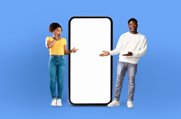 Poster - A man and a woman are standing side by side, looking at a blank screen on a phone. The man is holding the phone, while the woman is gesturing towards it with a curious expression.