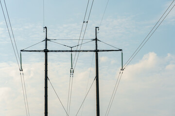 Wall Mural - Power lines and high-voltage wires against a background of blue sky and fluffy clouds. Energy infrastructure of Ukraine.