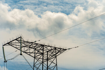 Wall Mural - Power lines and high-voltage wires against a background of blue sky and fluffy clouds. Energy infrastructure of Ukraine.