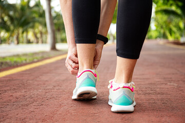 Wall Mural - runner woman tying up laces of shoes, getting ready to run for cardio and weight loss