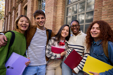 Portrait of a cheerful group of young multiracial student looking at camera having fun outside at university campus. Diverse happy friend hugging and smiling together outdoor. Community and friendship