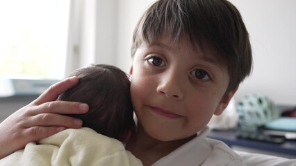 older sibling tenderly holding and comforting newborn baby in a yellow onesie, capturing the initial