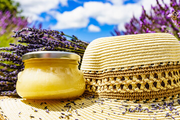 Summer hat and jar with honey at lavender field. Holidays in France.