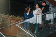 © qunica.com - Group of business professionals collaborating outdoors in a modern urban city environment, discussing work documents and ideas on a staircase.