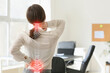 © Pixel-Shot - Young businesswoman suffering from back pain in office