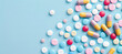 © Emmy Ljs - Colorful pills and tablets on a light blue background with copy space to add text or advertisement.Assorted Medicine Pills and Capsules for Health and Treatment.