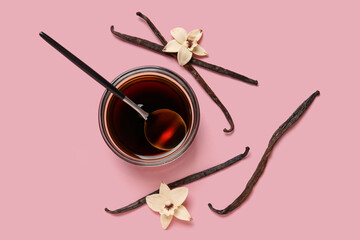 Wall Mural - Vanilla extract in bowl with spoon, vanilla pods and flowers on pink background. Top view