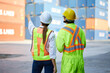 © offsuperphoto - back view workers looking and pointing above in containers warehouse storage