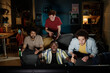 © AnnaStills - Group of ethnically diverse young men spending evening at home watching football game match on TV, copy space