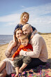 © DariaTrofimova - Sunny portrait of  loving family of parents and daughter with son on  beach by  sea