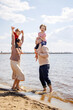 © DariaTrofimova - Sunny portrait of  loving family of parents and daughter with son on  beach by  sea
