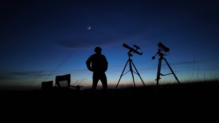 Wall Mural - amateur astronomer looking at the evening skies, observing planets, stars, moon and other celestial 