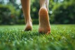 © Rainister - Closeup of a person s feet with natural toenails, walking barefoot on a grassy field