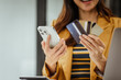 © M+Isolation+Photo - A young woman and other Asian individuals in formal suits are seen working at desks with laptops, possibly engaged in activities like online shopping using credit cards.