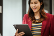 © M+Isolation+Photo - A young woman and other Asian individuals in formal suits are seen working at desks with laptops, portraying a successful and happy demeanor.