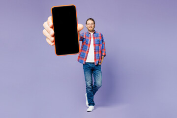 Wall Mural - Full body young happy man he wear blue shirt casual clothes hold in hand use close up mobile cell phone with blank screen workspace area isolated on plain pastel purple background. Lifestyle concept.