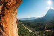 © zhukovvvlad - The girl climbs the rock. Climber trains on natural terrain. Extreme sport. Lessons on the street. A woman overcomes a difficult climbing route in Turkey.