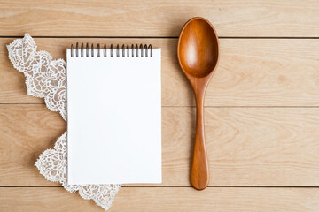 Wall Mural - Wooden Spoon and Blank Notebook on a Wooden Table