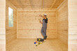 © UnitedPhotoStudio - Construction man, builder man construct new wooden home, tiny house style. Spirit level, screw, tool bag and charged drill. Wood shelter style.