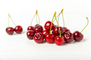 Cherries. Fresh ripe cherries with leaves on a textured wooden background. Fresh sweet organic cherry pile. Berries and fruits. Vegan. Healthy eating. Place for text. Copy space