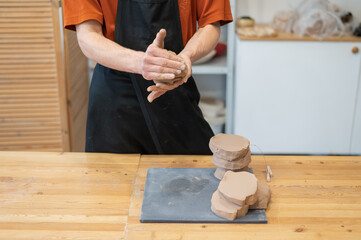 A potter kneads clay before using it in the workshop. Close-up of a man's hands. 