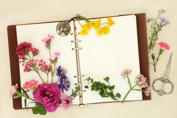 Wall Mural - British summer flowers herbs and wildflowers with notebook. Used in aromatherapy essential oils on hemp paper background.