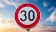 © hardvicore - Traffic sign 30 km/h, speed limit for speeding vehicles with blue sky and clouds on background.